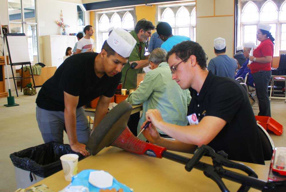 Tinkers Adam Lota & Dustin Buccino working on a weed wacker (Photo - Maelane Chan).
